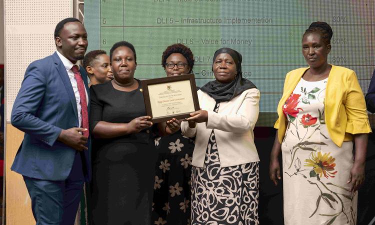 Hon. Minsa Kabanda - Minister for Kampala Capital City and Metropolitan Affairs recognizes Mpigi DLG for excellence during APA III launch at MoFPED Headquarters